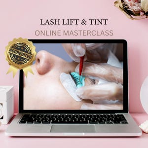 May include: A laptop computer screen shows a close-up of a person's eye with a lash lift and tint being applied. The laptop is on a pink surface with a gold seal that says "Accredited" on the left side of the screen. The text on the screen reads "Lash Lift & Tint Online Masterclass".