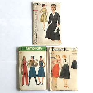 May include: Four vintage sewing pattern envelopes. The top envelope is Simplicity 5238, featuring a dress design. Below are Simplicity 7675 and Butterick 4685, showcasing various retro clothing styles. The patterns are printed in Canada.