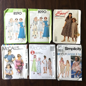 May include: Six vintage sewing patterns for girls' clothing. The patterns are for dresses, jumpers, and tops. The patterns are from Simplicity and McCall's.