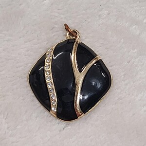 Small Gold Tone Black Enamel Pendant With Clear Stones