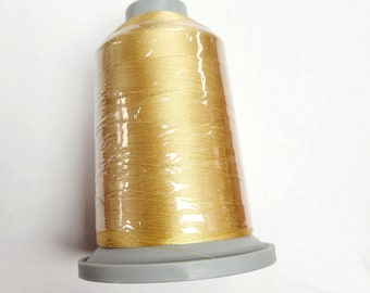 May include: A spool of gold thread wrapped in clear plastic, with a gray plastic base.