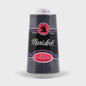 May include: A large spool of dark gray Maxi-Lock serger thread. The label features a black background with a pink circular logo containing a black sewing machine icon, the text Maxi-Lock, and a pink oval badge labeled All Purpose Spun Polyester.