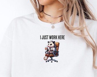 May include: A white t-shirt with the text "I just work here" and a cartoon possum sitting in an office chair.