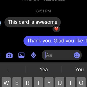 May include: Screenshot of a mobile phone screen displaying a text message conversation. The messages are in white and blue bubbles against a black background. The text reads "This card is awesome" and "Thank you. Glad you like it."