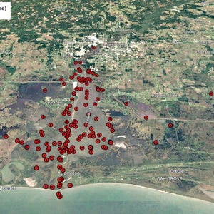 May include: An aerial view of Big Lake (Calcasieu Lake) with numerous red markers scattered across the water. The image, taken from Google Earth, shows the lake's location near Creole, Oak Grove, and Holly Beach. The landscape includes marshy areas and a coastal region.