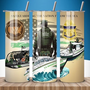 Könnte beinhalten: Drei Edelstahlbecher mit Illustrationen von US-Grenzschutzbeamten und Booten. Die Becher zeigen den Text "SAFEGUARDING THE NATION FROM THE SEA" und verschiedene Logos des US-Grenzschutzes. Der Hintergrund zeigt die amerikanische Flagge und Wellen.