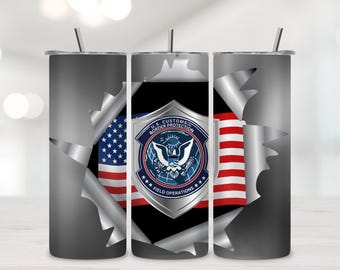 May include: A stainless steel tumbler with a U.S. Customs and Border Protection design. The design features the American flag and the agency's emblem, set against a torn metal background. Includes a silver straw.