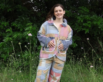 May include: A matching two-piece set consisting of a long-sleeved button-up jacket and trousers, both crafted from a quilted patchwork fabric featuring a mix of blue, tan, red, and white gingham, floral, and star-patterned textile squares.