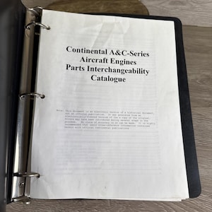May include: An open black binder with a white page featuring the text "Continental A&C-Series Aircraft Engines Parts Interchangeability Catalogue." The page also includes a disclaimer about the document's electronic nature.