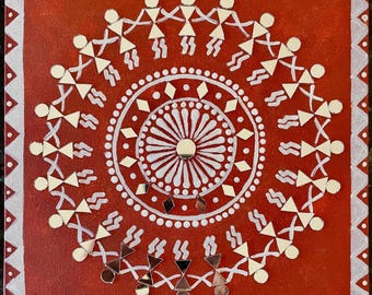 Op de afbeelding: Een rood canvas schilderij met een wit mandala-ontwerp in het midden. De mandala wordt omringd door een cirkel van witte stokfiguren die elkaars handen vasthouden. De stokfiguren zijn versierd met kleine, gespiegelde stukjes.
