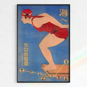 May include: Vintage Japanese poster featuring a woman in a red swimsuit and swim cap poised to dive. The poster has Japanese text and a blue background. The woman is standing on a brown platform. The poster is framed in a black frame.