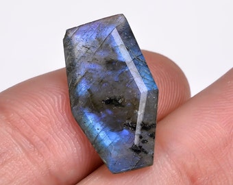 May include: A faceted, iridescent blue labradorite gemstone with a hexagonal shape.