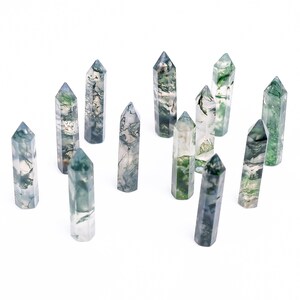 May include: A collection of twelve green and white moss agate crystal points, each with a unique pattern and shape.