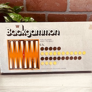 May include: A vintage backgammon game box with a brown and orange game board, 30 plastic checkers, and dice. The box is white with black text that reads "Backgammon" and "For 2 Players Ages 7 to Adult".