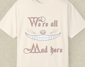 チェシャ猫のコンフォートカラーTシャツ「私たちはみんなここが狂っている」 - 不思議の国のアリスシャツ