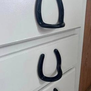 Puede incluir: Tres cajones blancos con tiradores en forma de herradura negros.