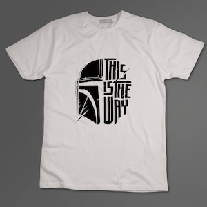 May include: White t-shirt with a black graphic of a Mandalorian helmet and the text "This is the way".