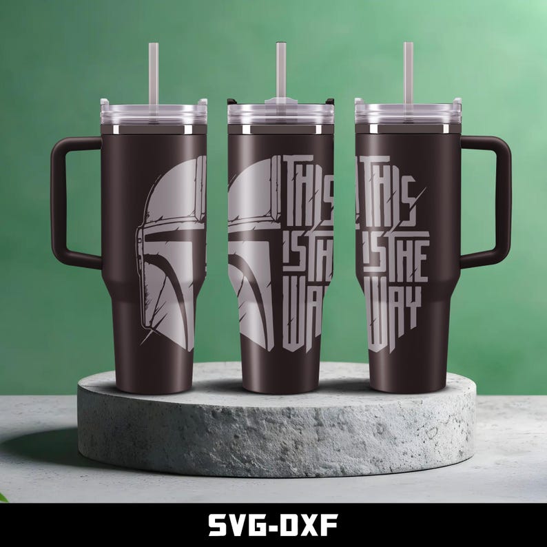 May include: Three stainless steel tumblers with lids and handles. The tumblers are black with white text and a graphic of a Mandalorian helmet. The text on the tumblers reads "This is the way".