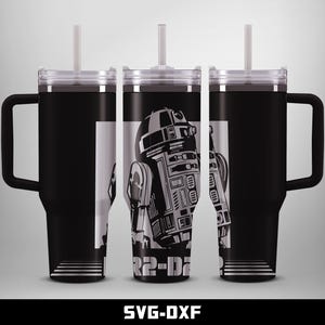 Könnte beinhalten: Schwarzer Becher mit Griff, mit einer schwarz-weißen Grafik der Star Wars-Figur R2-D2. Der Becher hat einen transparenten Deckel und einen weißen Strohhalm. Der Text "R2-D2" ist auf dem Design sichtbar.