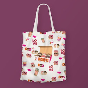 K&ouml;nnte beinhalten: Wei&szlig;e Canvas-Tragetasche mit einem rosafarbenen und orangenen Donut-Muster. Die Tasche zeigt eine Schachtel Donuts mit dem Text "DONUTS" und die W&ouml;rter "LOVE" und "DD" wiederholen sich im gesamten Design.
