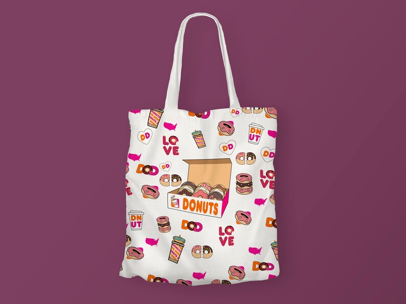 K&ouml;nnte beinhalten: Wei&szlig;e Canvas-Tragetasche mit einem rosafarbenen und orangenen Donut-Muster. Die Tasche zeigt eine Schachtel Donuts mit dem Text "DONUTS" und die W&ouml;rter "LOVE" und "DD" wiederholen sich im gesamten Design.
