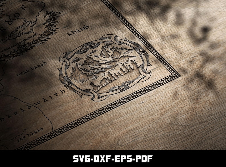 May include: A detailed map illustration, featuring a mountain range within an ornate frame, is etched onto a wooden surface. The map includes text such as "Khand" and "Near Barad". The bottom of the image displays the text "SVG-DXF-EPS-PDF".