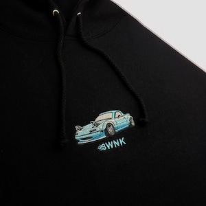 May include: Black hoodie featuring an embroidered blue car and the text "SWNK" on the front.