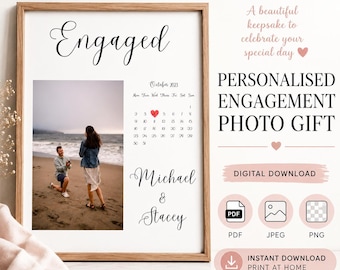 May include: A framed personalized engagement photo gift print featuring the word Engaged in script, a photograph of a couple on a beach, a calendar for October 2023 with a red heart on a specific date, and the names Michael and Stacey in script.