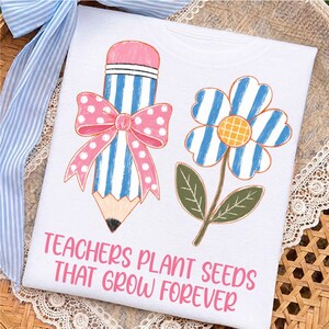 Peut inclure: Un t-shirt blanc avec un motif représentant un crayon rayé bleu et blanc orné d'un nœud rose à pois, ainsi qu'une fleur rayée bleu et blanc au centre jaune. Le texte "TEACHERS PLANT SEEDS THAT GROW FOREVER" est écrit en lettres roses.