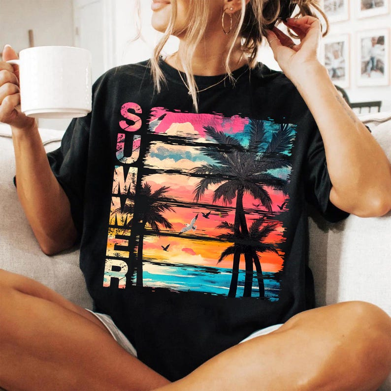 May include: Black t-shirt with a colorful graphic of a tropical sunset, palm trees, and the word "SUMMER" in vertical text. The design features shades of pink, orange, blue, and yellow, evoking a beachy vibe. A casual, relaxed fit.