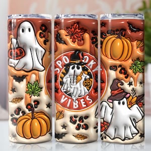 May include: Three 20 oz stainless steel tumblers with a Halloween theme. The tumblers feature a white ghost with a pumpkin, a ghost with a witch hat, and a ghost with a witch hat and a pumpkin. The tumblers have a white background with orange, black, and green accents. The text "Spooky Vibes" is on the tumbler with the ghost wearing a witch hat.
