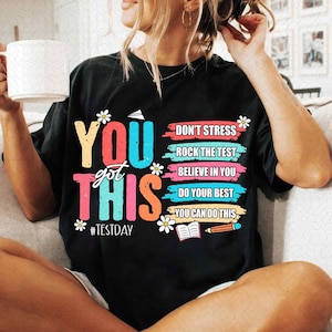 May include: Black t-shirt with a colourful graphic that says "You got this" and includes the text "Don't stress, Rock the test, Believe in you, Do your best, You can do this" and the hashtag "#Testday".