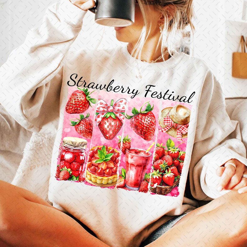 Op de afbeelding: Een wit sweatshirt met de tekst "Strawberry Festival" erop gedrukt. Het ontwerp bevat verschillende aardbeien, een pot aardbeienjam, een aardbeientaart, een aardbeien smoothie en een mand met aardbeien.