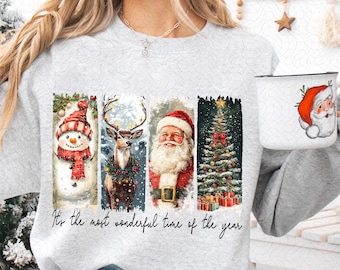 Op de afbeelding: Een grijs sweatshirt met een kerstthema-ontwerp met een sneeuwpop, een hert, de kerstman en een kerstboom. De tekst "It's the most wonderful time of the year" staat onder het ontwerp.