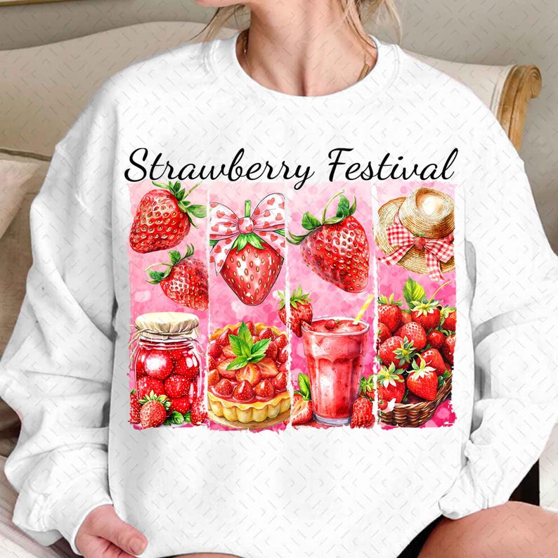 Op de afbeelding: Wit sweatshirt met een roze en rood aardbeienfestival ontwerp. Het ontwerp bevat aardbeien, een pot jam, een aardbeientaart, een glas aardbeisap en een strohoed.