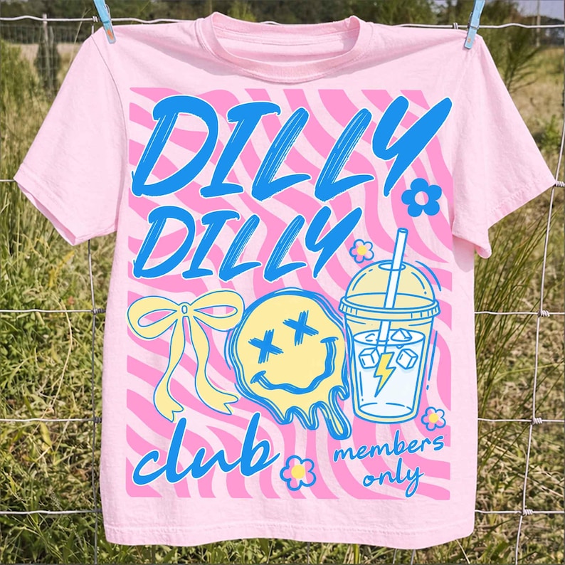May include: Pink t-shirt with a wavy pink and white background design. The shirt features the words "DILLY DILLY CLUB" in blue script, along with a yellow melting smiley face, a bow, a drink, and the words "members only".