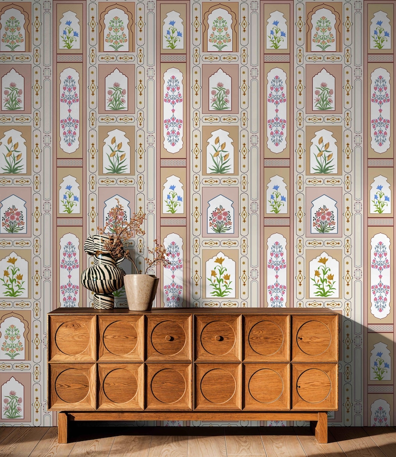May include: A wooden dresser with a mid-century modern design. The dresser has a light brown finish and features a repeating pattern of circular cutouts on the front. The dresser is in front of a wall with a patterned wallpaper featuring a repeating design of floral motifs and arches in shades of pink, beige, and blue.