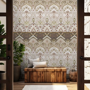 May include: A wooden bench with two pillows sits in front of a wall with a patterned wallpaper. The wallpaper features a repeating design of brown, gold, and white arches with floral details. The bench is in a room with a wooden floor and two doorways.