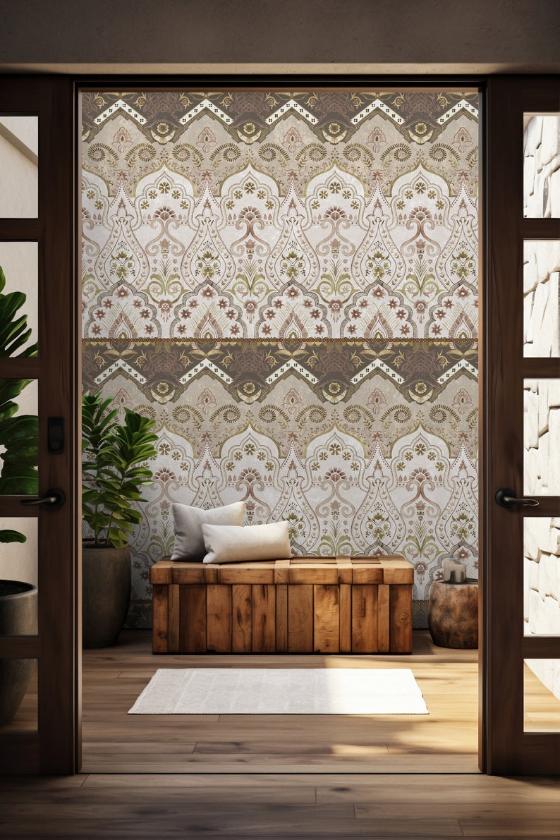 May include: A wooden bench with two pillows sits in front of a wall with a patterned wallpaper. The wallpaper features a repeating design of brown, gold, and white arches with floral details. The bench is in a room with a wooden floor and two doorways.