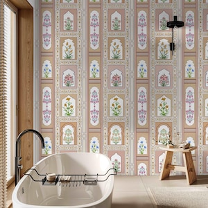 May include: A white bathtub with a black metal rack sits in a bathroom with a beige and pink patterned wallpaper featuring floral designs and arches. A wooden stool is in the foreground.