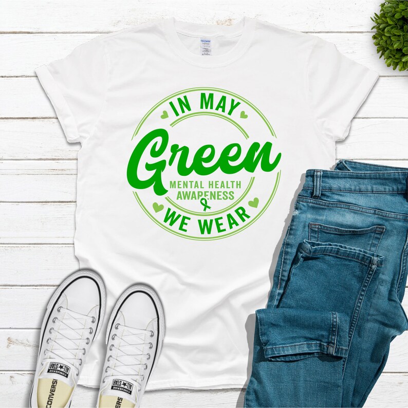 May include: White t-shirt with a green circle graphic that says "In May We Wear Green" and "Mental Health Awareness".