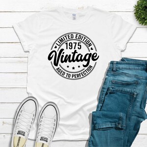 May include: White t-shirt with a black circle graphic that says "Limited Edition 1975 Vintage Aged to Perfection".