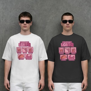 Può includere: Due persone indossano magliette bianche e nere con la scritta "I Support LGBTQ" e grafiche rosa. Le grafiche includono immagini di liquori, pistole, birra, tacos e quickies. Entrambe le persone indossano occhiali da sole e pantaloni bianchi.