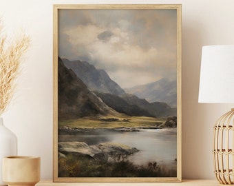 Op de afbeelding: Een ingelijst landschapschilderij van een meer omringd door bergen. De lucht is bewolkt en het water is kalm. Het schilderij is in een houten lijst en hangt aan een muur.