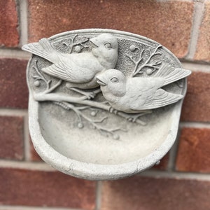 stone/concrete wall hanging two birds bird feeder bird bath garden ornament