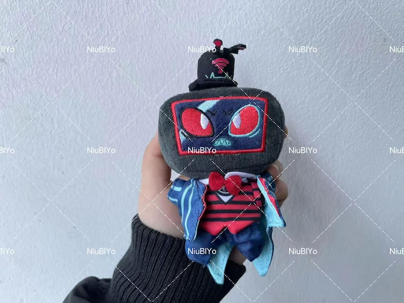 May include: A plush toy in the shape of a television set, complete with a top hat. The screen features red eyes and a blue design. It has a red bow tie and a striped vest, with blue and white accents.