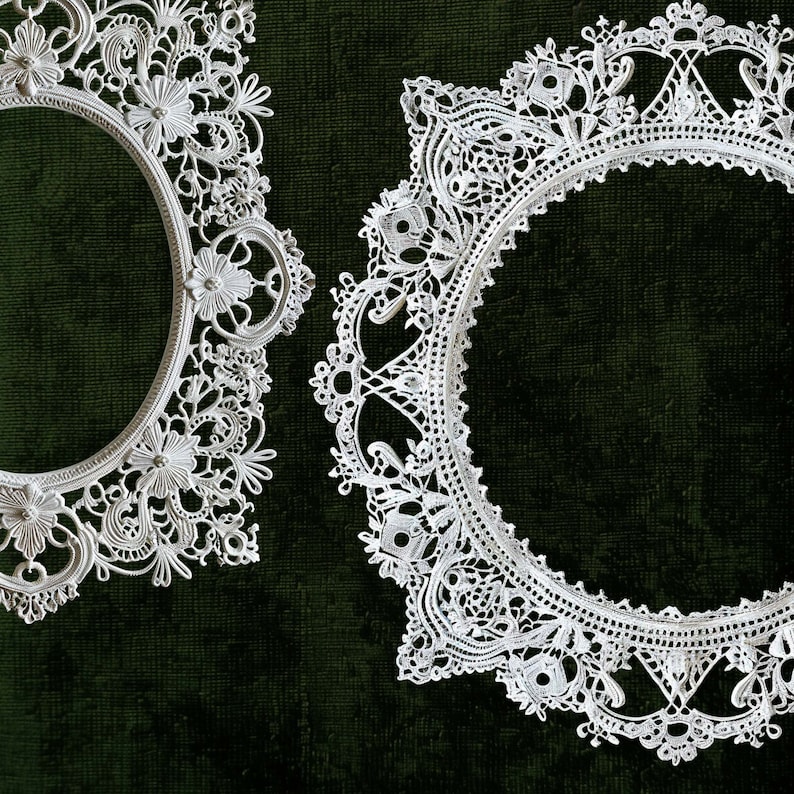 May include: Two white lace doilies with circular frames on a dark green background.