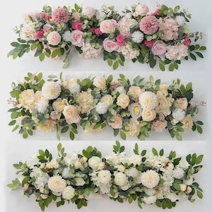 Op de afbeelding: Drie bloemstukken met roze, witte en crèmekleurige bloemen en groene bladeren. De arrangementen bevatten rozen, hortensia's en andere bloemen, ideaal voor bruiloften of huisdecoratie. Elke compositie is ongeveer 60 cm lang.