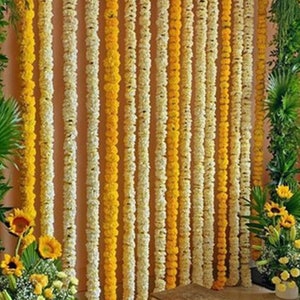以下が含まれることがあります： 黄色と白の花輪で飾られた結婚式用の背景。花輪は縦に並べられており、視覚的に魅力的で祝祭的な雰囲気を作り出しています。