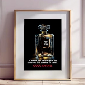 Peut inclure: Impression encadrée d'un flacon de parfum avec le texte "COCO CHANEL". Le flacon est rectangulaire avec un dessus transparent à facettes et un col doré. Le texte "Une femme doit porter du parfum partout où elle veut être embrassée" est également affiché.